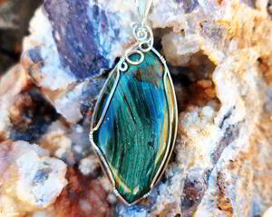 Handmade Gary Green Jasper pendant wrapped in sterling silver wire, featuring deep green, blue-green, and tan hues in an elegant design.